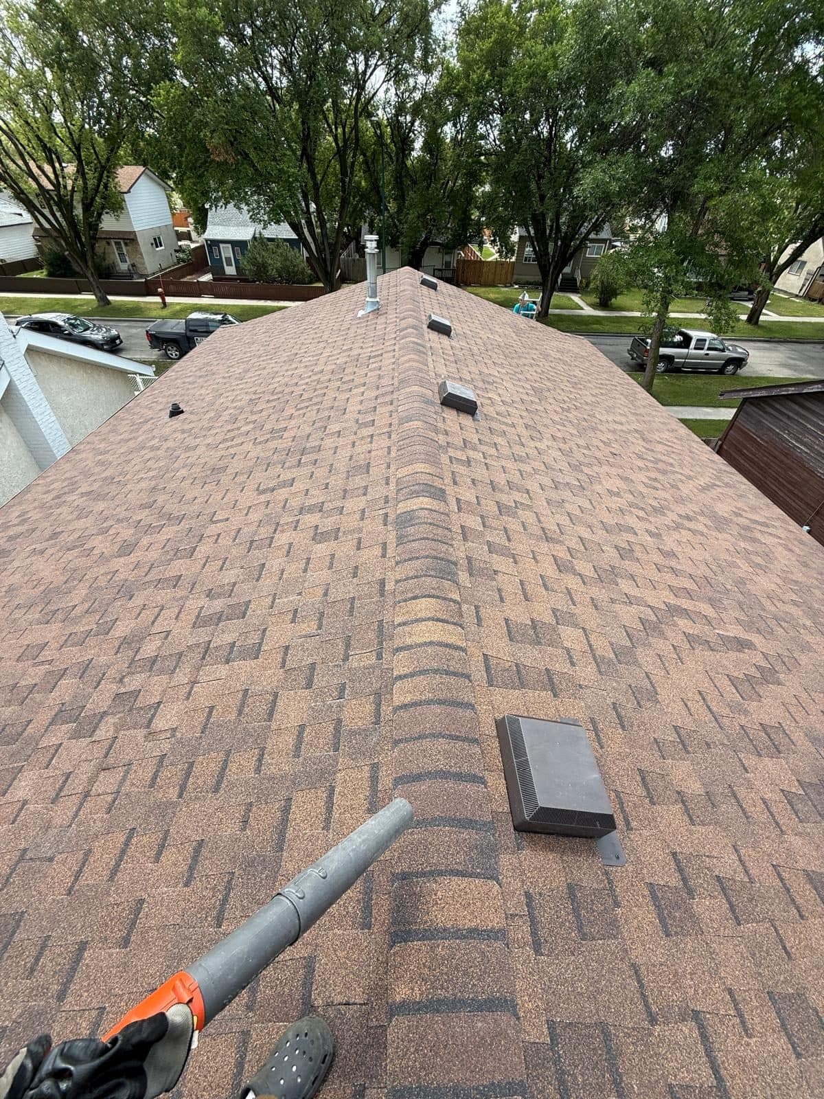 Red shingle roof installation in progress